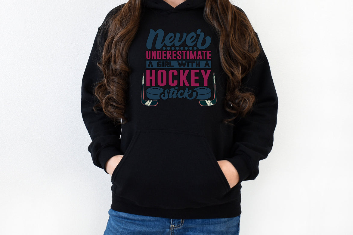 Black Gildan 18500 unisex crewneck sweatshirt. It says never underestimate a girl with a hockey stick in dark blue and hot pink. There are two pucks beside the word stick. There are hockey sticks on either side of the text.