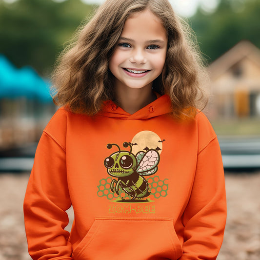 Girl wearing an orange Gildan 18500B youth hoodie. It has a drawing of a green and black zombie bee in the middle with a moon with bats and green honeycomb behind it. It says zom-bee at the bottom in a green drippy font.