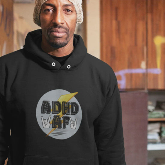Video on a man in a premium unisex black hoodie that says adhd af in a room with graffitied walls