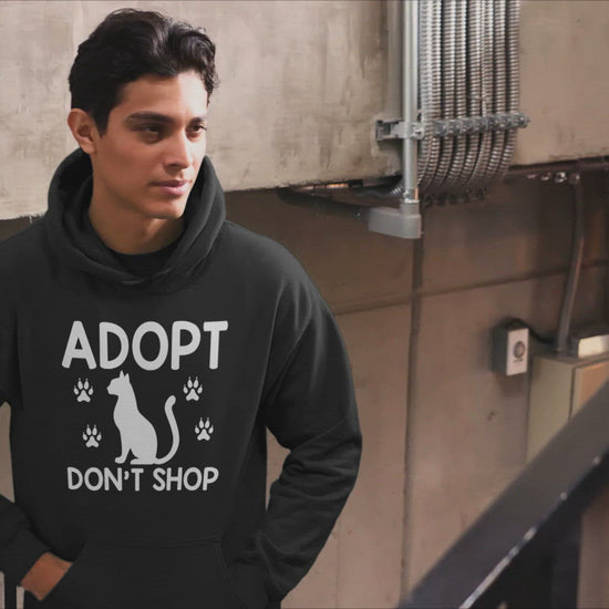 Video of a man wearing a black hoodie that says adopt don't shop